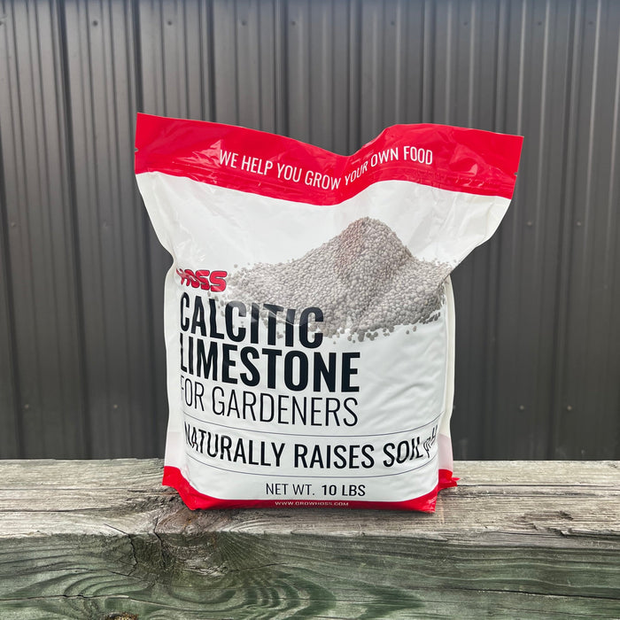 Bag of calcitic limestone for gardeners on a wooden surface with a metal wall background
