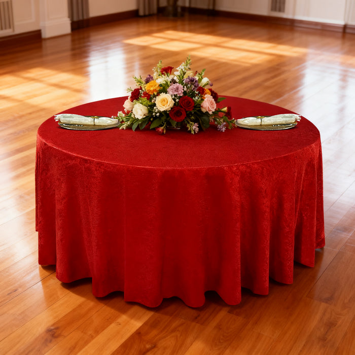 Crinkle Shimmer 120" Round Tablecloth Red table setting with floral centerpiece, gold charger plates and ivory napkins