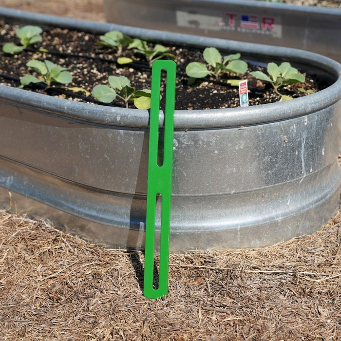 Spreader bar leaned up against a raised bed